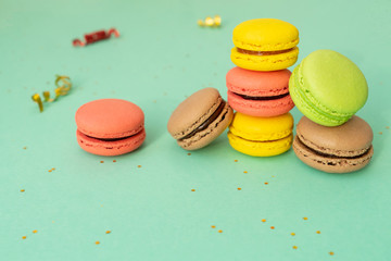 Sweet and colourful french macaroons on turquoise.