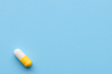 One capsule on a blue background, space for text