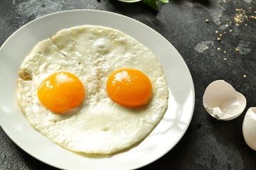 Fried eggs in a plate. Fried eggs close-up. Tasty and healthy breakfast. Yolk close-up.