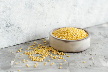 Raw dry hulled millet in a ceramic bowl