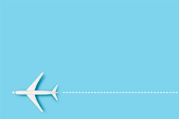 Airplane and line indicating the route on a blue background. Concept travel, airline tickets, flight, route pallet. Banner. Flat lay, top view - obrazy, fototapety, plakaty