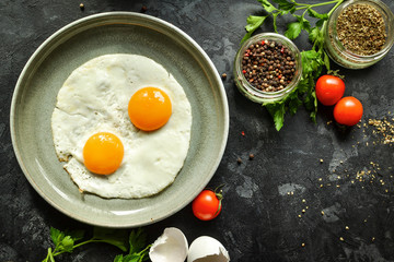 Scrambled eggs for breakfast. Perfect fried eggs in a gray plate. Ingredients. Top id. Dark background.