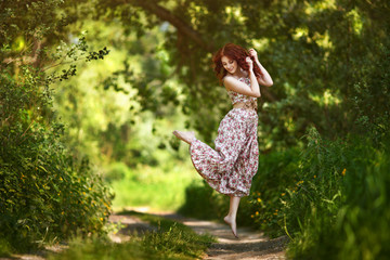 The red-haired girl walks in the forest