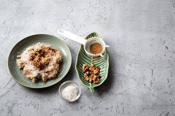 Spelled porridge with coconut, walnut, cinnamon and honey. Proper nutrition concept.