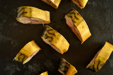 Hot smoked mackerel. Fish on a dark background, close-up.Fish pieces