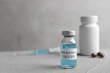 Chickenpox vaccine and syringe on grey table, space for text. Varicella virus prevention