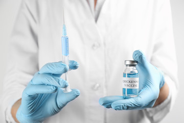 Fototapeta premium Doctor holding chickenpox vaccine and syringe, closeup. Varicella virus prevention