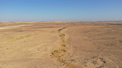 Aerial view of Negev desert landscape, Ezuz village, Israel on the border with Egypt. Hot sunny day. Blue sky, sand.