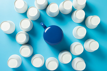 Cup is surrounded by empty Paper cups for drinks on a blue background. Banner. Flat lay, top view