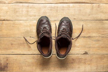 Hiking boots on a wooden background. The concept of hiking, tourism, camp, mountains, forest. Banner. Flat lay, top view
