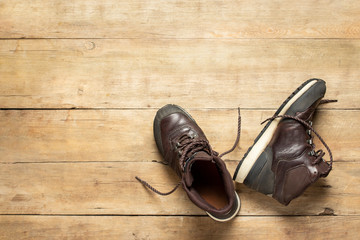 Hiking boots on a wooden background. The concept of hiking, tourism, camp, mountains, forest. Banner. Flat lay, top view