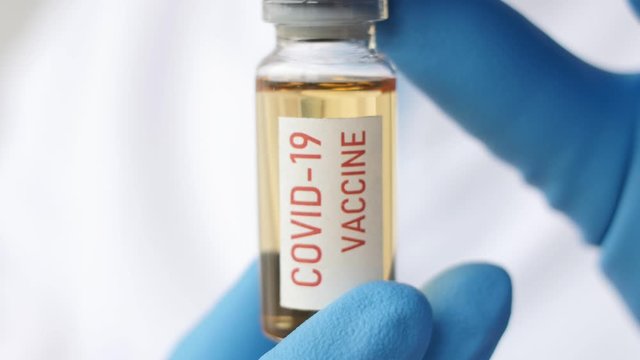 Medical doctor or laborant holding tube with nCoV Coronavirus vaccine for 2019-nCoV COVID virus. Novel Coronavirus originating in Wuhan, China. Coronavirus 2019-nCoV COVID concept.