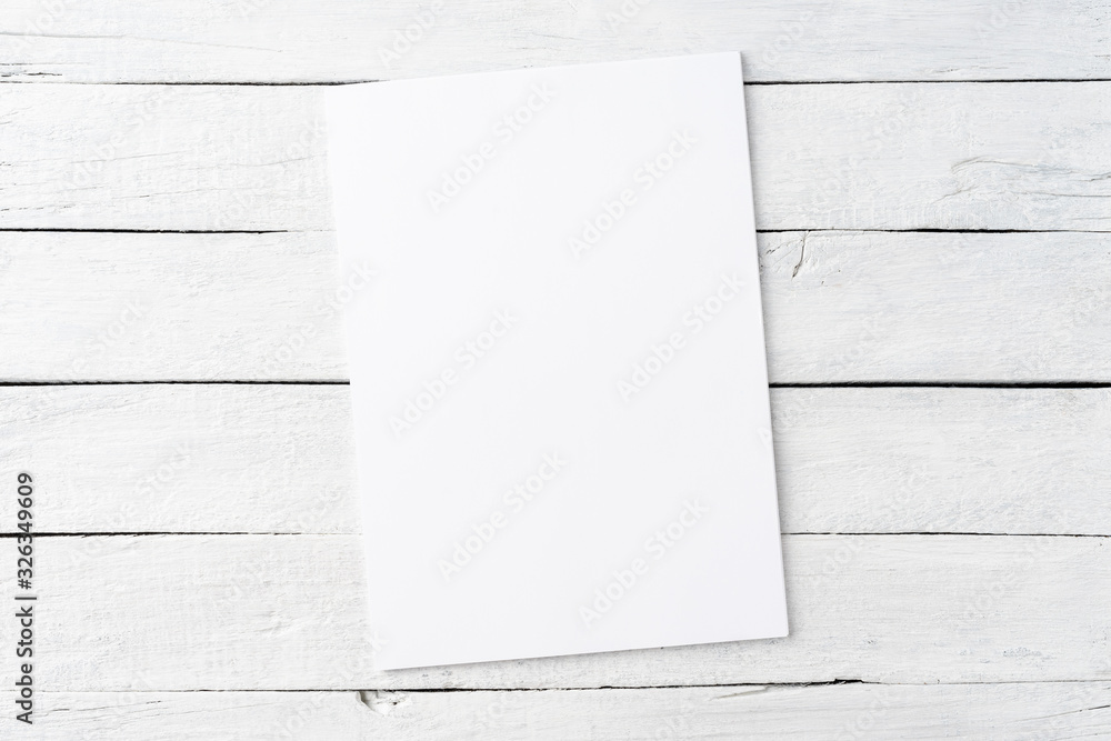 Wall mural blank white sheet of paper on rustic wooden background. top view