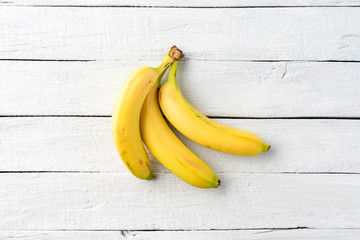 Bunch of fresh bananas on white wooden table. Close up