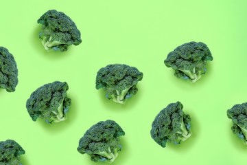 Broccoli on a green background. Seamless food pattern in a minimalistic style, photo collage. Concept of diet, healthy food. Top view, flat lay, copy space for text.