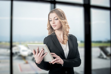 Beautiful business woman working on laptop while waiting for her flight in an airport