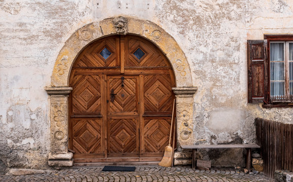 Old wooden door with an ancient arch as a frame, in Tarasp Switzerland