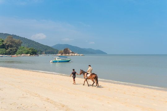 Horse riding at the Batu Ferringhi beach on the island of Penang. The small town is the prime beach destination in Penang among locals and tourists