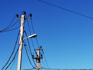 New electric blue shield with black wires on a background of clear sky on a sunny day. High voltage network. Solar pure energy.