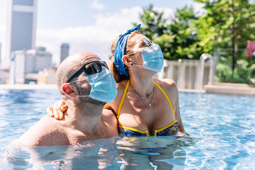 tourists wear the protective mask in the pool to protect themselves from the coronavirus