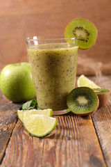 kiwi, apple and lemon smoothie, fruit juice on wood background