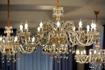 Luxury chandelier on the ceiling of a luxury restaurant.  Selective focus. - obrazy, fototapety, plakaty