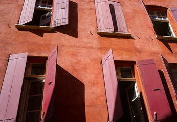 Fototapeta na wymiar Red shutters on the windows of a house with red walls in the Old City