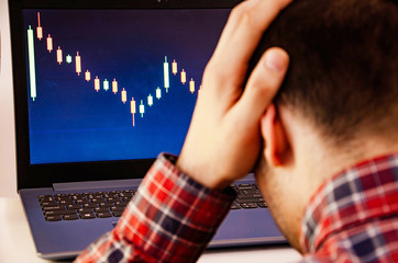 Trading on the exchange. A man is holding his head. Losing rates, promotions. Win, lose.  Good luck...