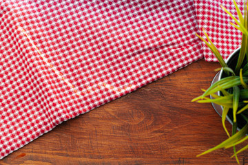 Red checkered napkin or tablecloth  on wooden table, copy space