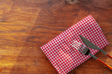 Obraz premium Red checkered napkin or tablecloth on wooden table, copy space