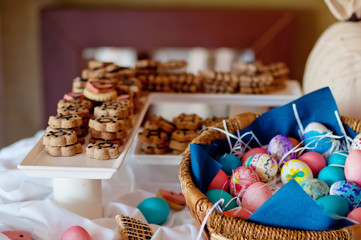 Colorful easer eggs in a basket on Easter brunch buffet table. Happy Easter concept