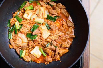 Stir-fried pork with kimchi in cooking pan, homemade Korean food