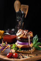 Meat burger with on wooden Board for take away with cabbage salad, vegetables and cheese. On black background