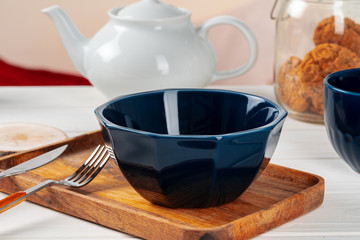 Empty blue ceramic bowl on kitchen table close up