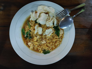 mie dok dok is Indonesian noodles soup made from fried instan noodles with gravy egg, vegetables and crackers