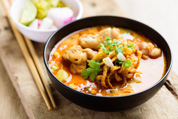 Traditional Northern Thai food (Khao Soi), spicy curry noodles soup with coconut milk and chicken in a bowl
