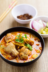 Traditional Northern Thai food (Khao Soi), spicy curry noodles soup with coconut milk and chicken in a bowl