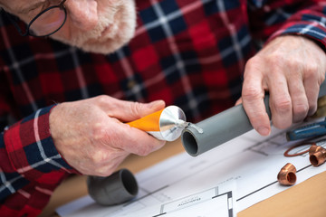 Plumber applying glue on pvc pipe