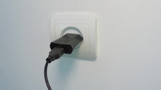Smoke escapes from USB charger of smartphone connected to electrical outlet