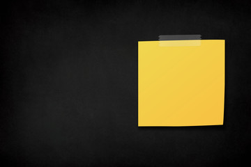 Yellow sticky note on a black background