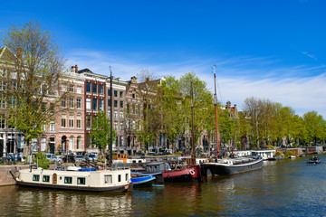 Fototapeta na wymiar Buildings and boats along the canal in Amsterdam, Netherlands