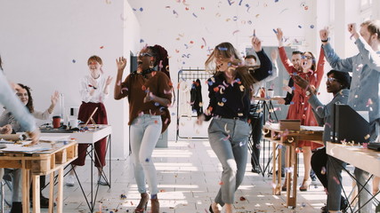 RED EPIC-W Happy young multiethnic female colleagues celebrate success with team and confetti at office slow motion.
