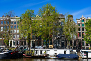 Fototapeta premium Buildings and boats along the canal in Amsterdam, Netherlands