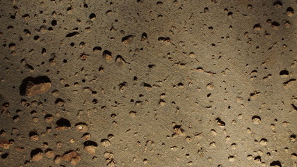  background macro image of gray-brown surface with round holes