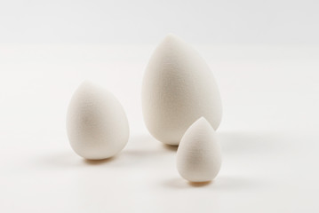 Small, medium and large  white beauty blender isolated.