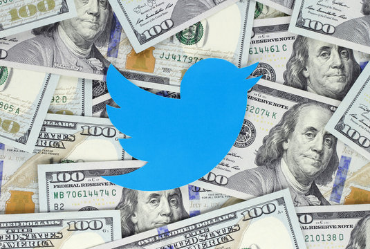 Kiev, Ukraine - September 07, 2018: Twitter bird icon printed on paper, cut and placed on money background. Twitter is an American online news and social networking service