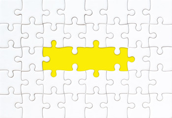 White jigsaw puzzle with empty space for your text and yellow background