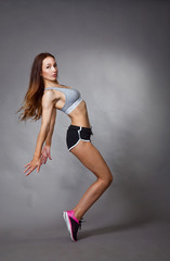 Fototapeta premium Young sexy athletic girl shows off her body in the Studio after a workout