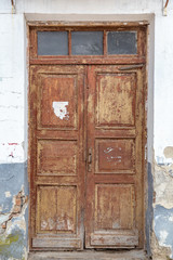 Vintage retro wooden door in legacy building with peeling old paint.