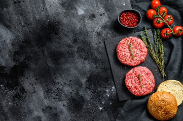 Recipe for burgers with marbled beef patties, cutlets. Black background. Top view. Copy space